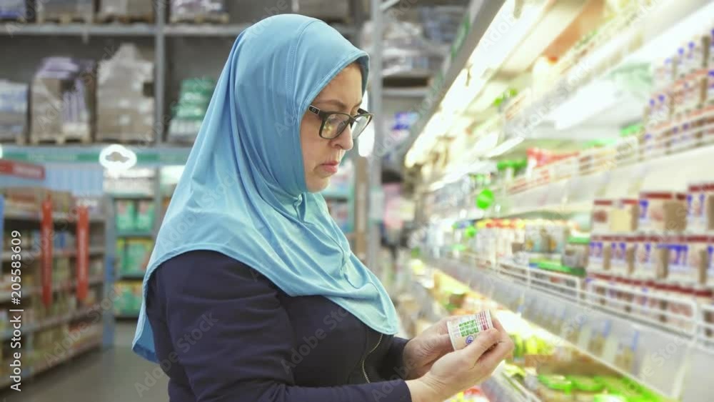 woman in hijab 40 years shopping, chooses baby food woman in hijab 40 years shopping, chooses baby food