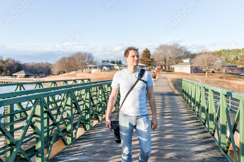 Lake Fairfax Park in winter in Reston, Virginia with young man photographer walking with professional camera for photo shoot session in Northern VA photo