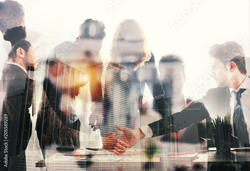 Handshaking business person in office. concept of teamwork and partnership. double exposure