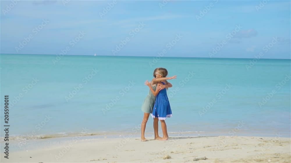 Little happy funny girls have a lot of fun at tropical beach playing together. Little happy funny girls have a lot of fun at tropical beach playing together.