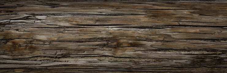 Old Dark rough wood floor or surface with splinters and knots. Square background with flooring or boards with wood grain. Old aged timber in a barn or old house.