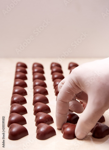 Heart-shaped chocolates being ordered by a gloved hand