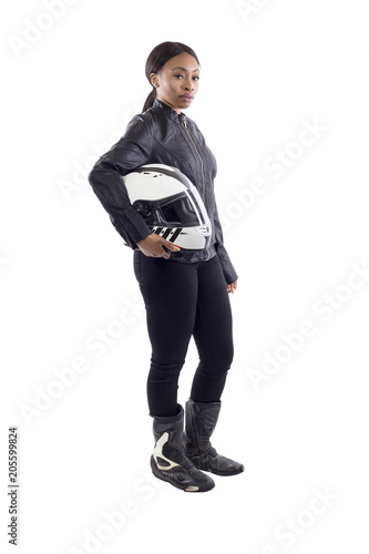 Confident strong black female holding a helmet as a race car driver, motorcycle biker or a stuntwoman.  The image depicts feminism by portraying a gritty woman of extreme motorsports.