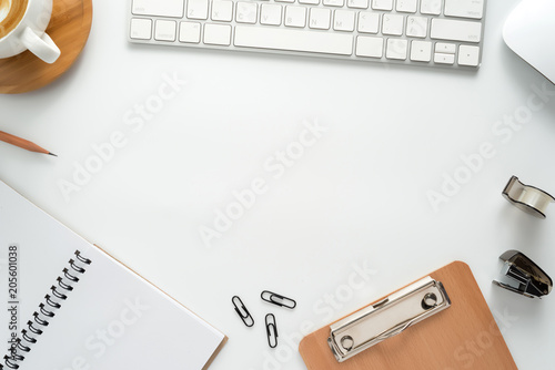 Flat lay, top view office table desk. Workspace with blank note book, keyboard, office supplies  and coffee cup on white background.