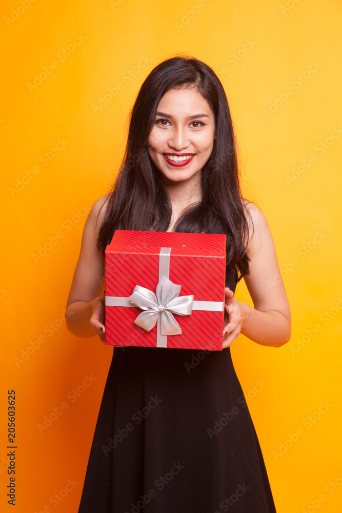 Fototapeta premium Asian woman thumbs up with a gift box.