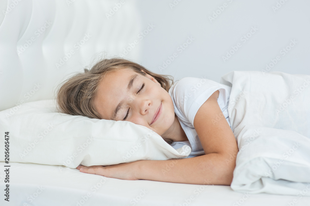Smiling little girl sleeping on the bed. Space for text Smiling little girl sleeping on the bed. Space for text