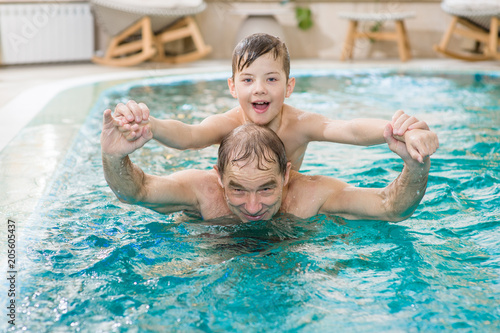 grandfather having fun with his grandson in the pool