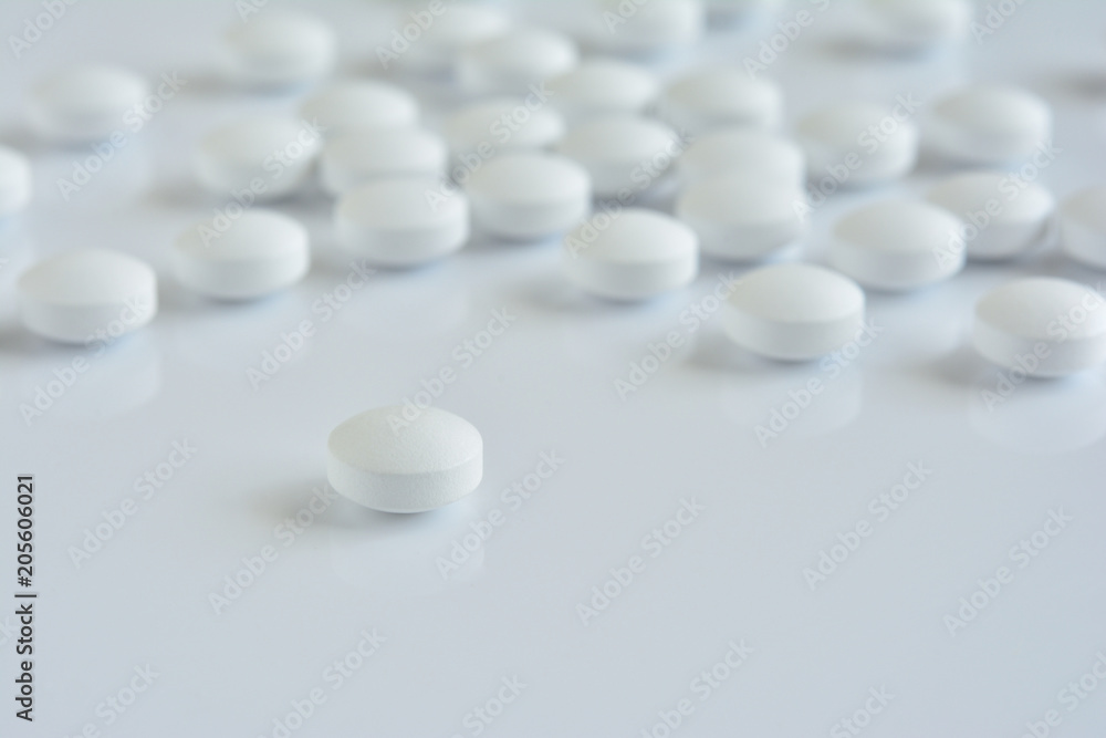 White pills on a white background
