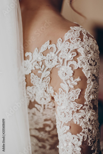 stylish bride detail, luxury lace gown on shoulder and red hair curl with veil, beautiful wedding dress. rustic wedding morning preparation. bridal getting ready. emotional moment. space for text