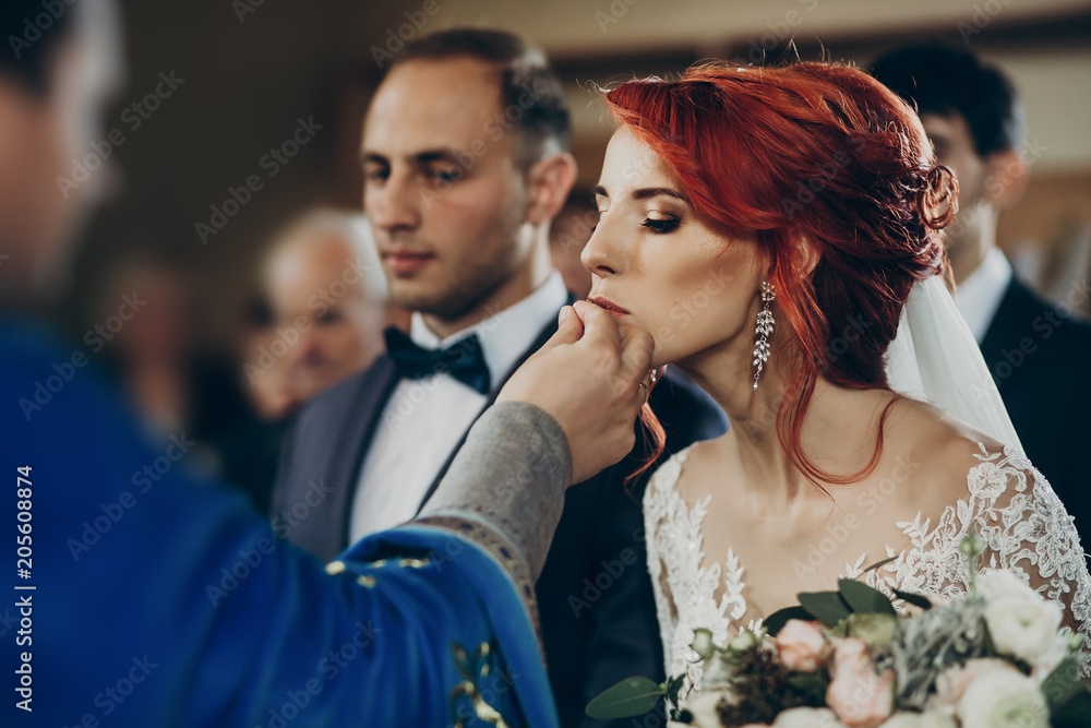 wedding couple putting on wedding rings at matrimony in church. stylish bride and groom kissing and exchanging rings. emotional moment, space for text. religion concept wedding couple putting on wedding rings at matrimony in church. stylish bride and groom kissing and exchanging rings. emotional moment, space for text. religion concept