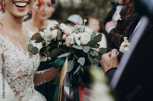 Fotografija stylish happy bride holding modern bouquet and smiling