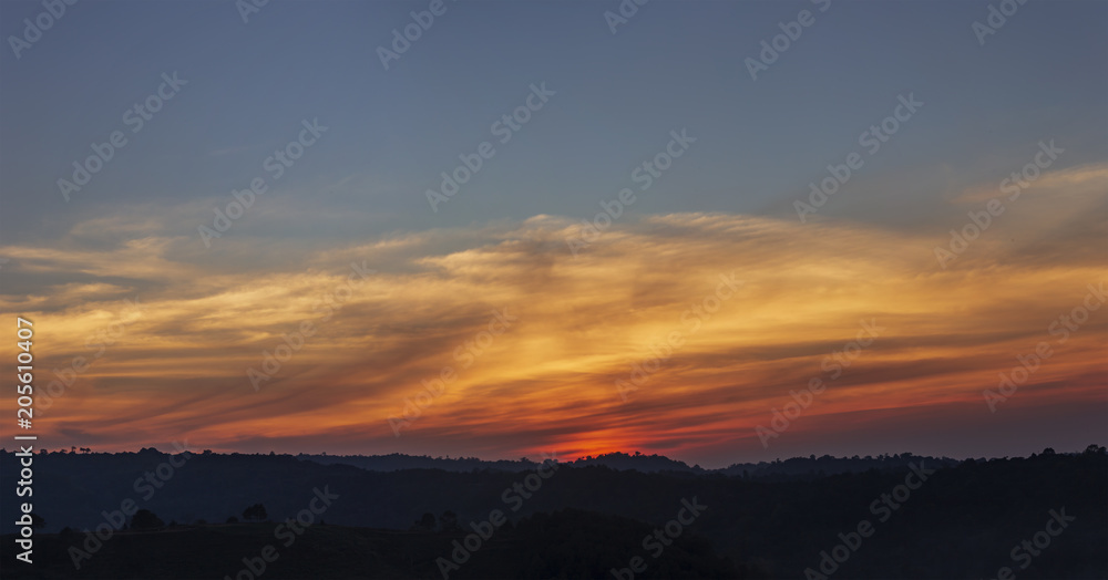 Panorama view of orange sunrise and cloud over silhouette mountain