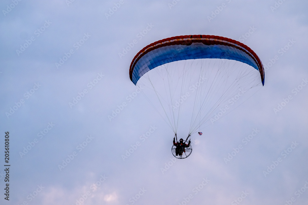 Paraglider flying with paramotor during sunset Paraglider flying with paramotor during sunset