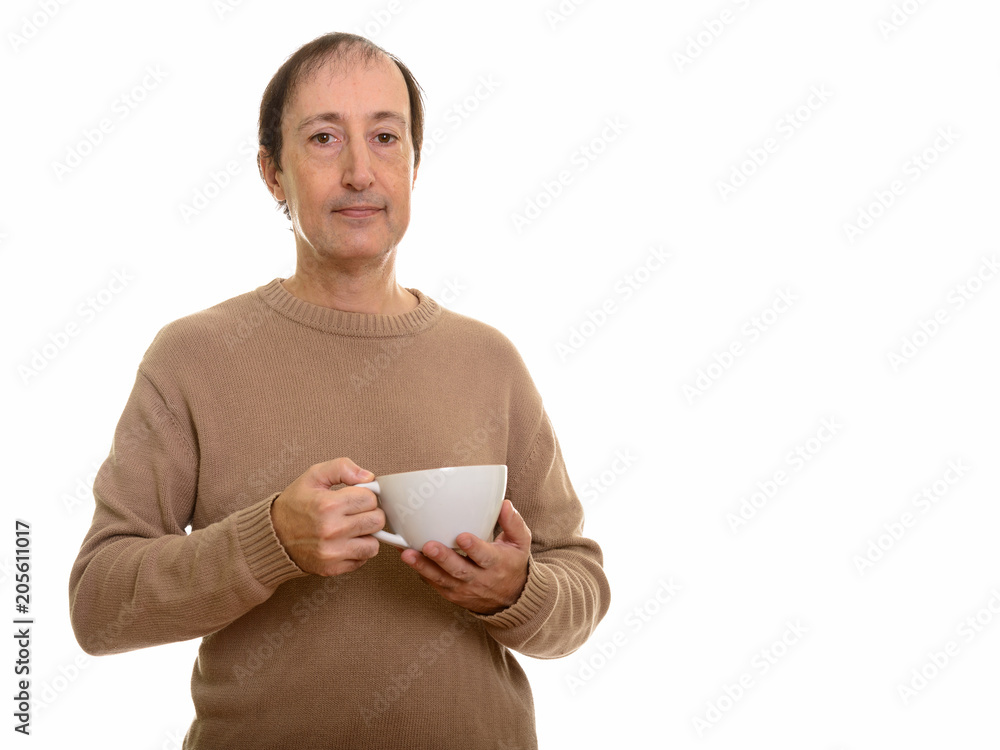 Studio shot of mature man holding coffee cup Studio shot of mature man holding coffee cup