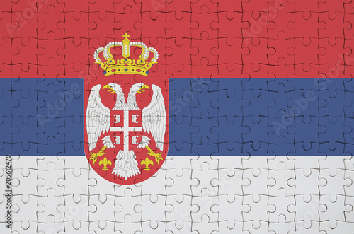 Serbia flag  is depicted on a folded puzzle photo