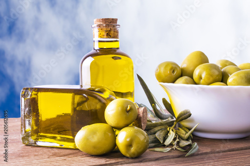 bowl of olives and bottle of extra virgin oil on background