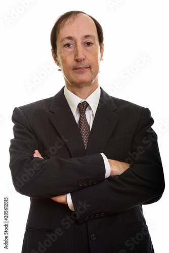 Studio shot of mature businessman with arms crossed