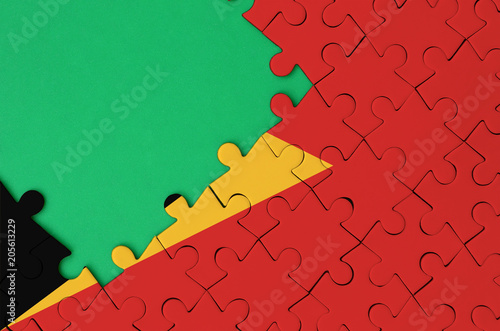 Timor Leste flag  is depicted on a completed jigsaw puzzle with free green copy space on the left side photo