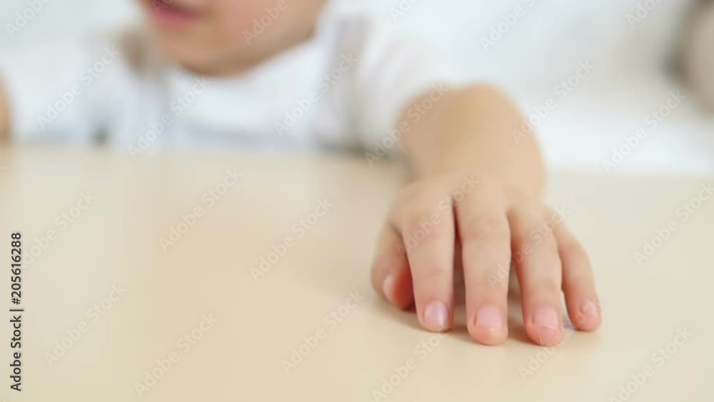 A kid shows his hand close-up on a table