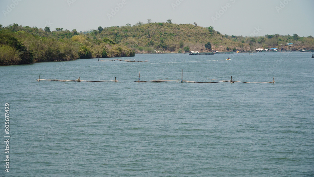 Fish farm with cages for fish and shrimp in the Philippines, Luzon. Fish ponds for bangus, milkfish. Fish cage for tilapia, milkfish farming aquaculture or pisciculture practices.