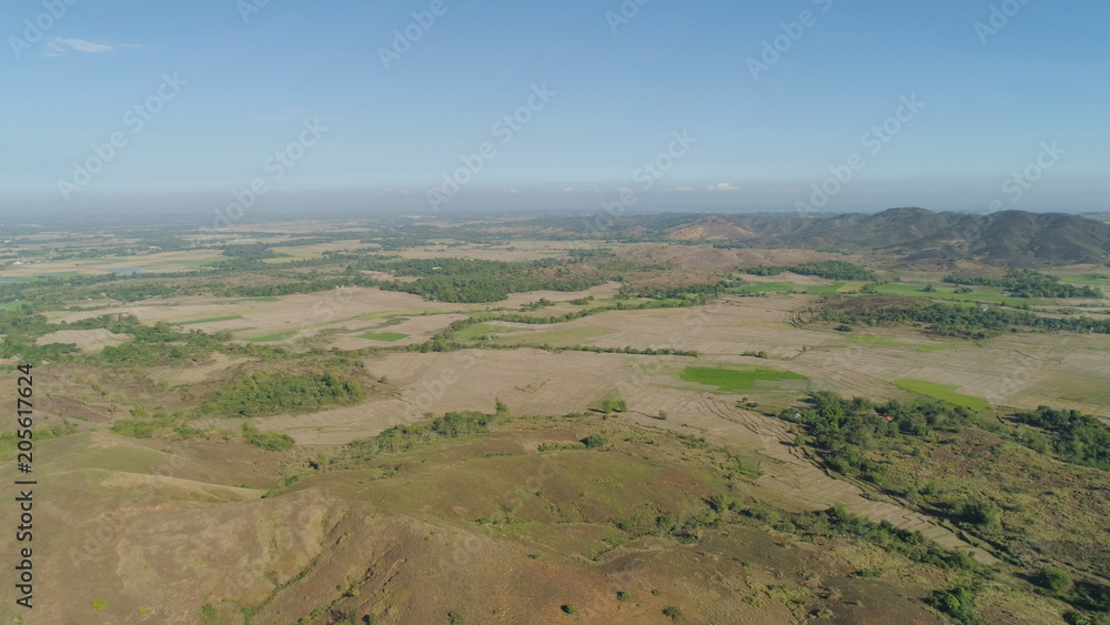 Mountain valley with village, farmland in the Philippines, Luzon. Aerial view: Mountain valley with green trees and river.