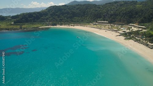 Aerial view of beautiful tropical beach with turquoise water in blue lagoon, Pagudpud, Philippines. Ocean coastline with sandy beach. Tropical landscape in Asia. © Alex Traveler