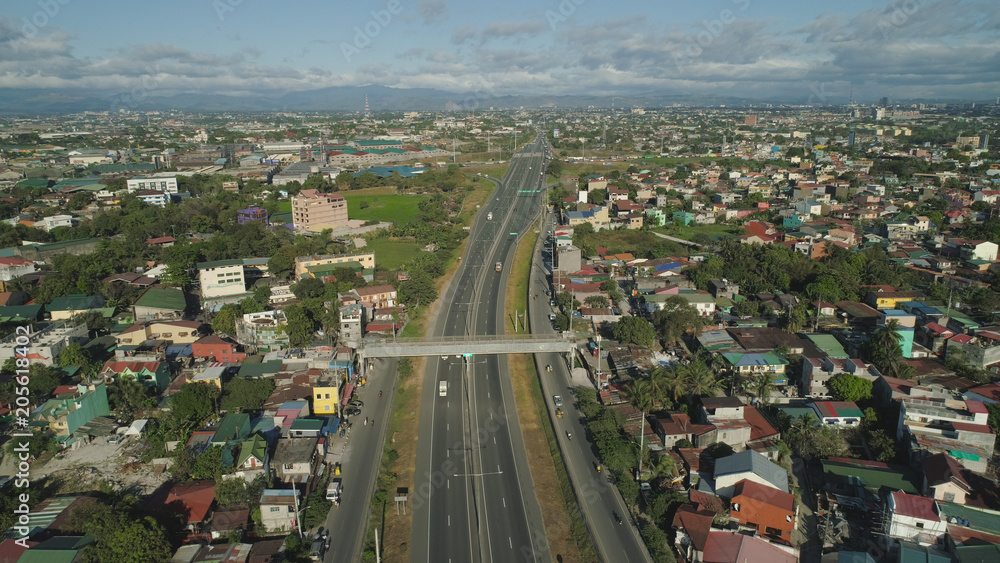 Aerial view of highway with road junction, car and traffic in Manila, Philippines. Highway in Manila among residential buildings. View of highway intersection.