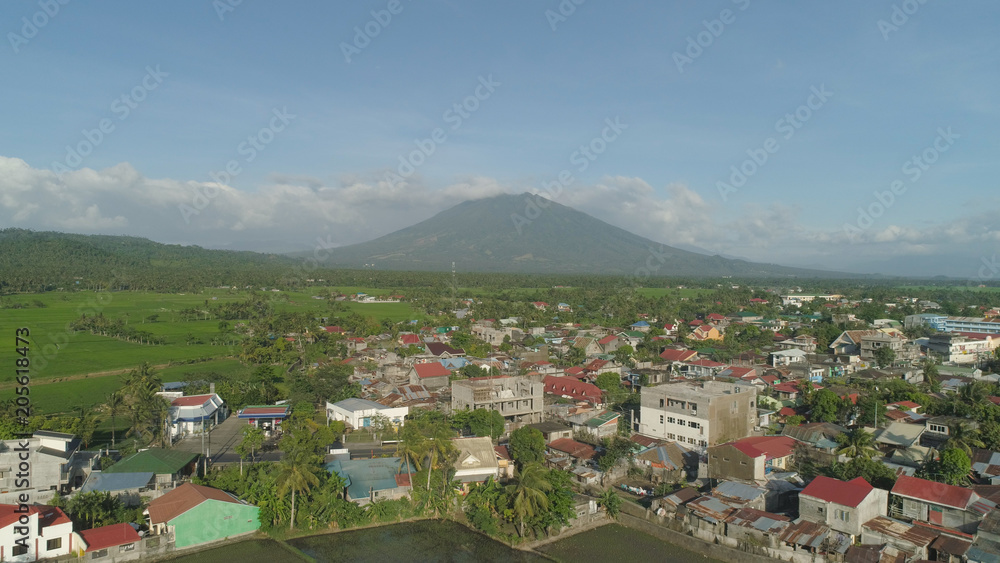 Aerial view of town in a mountain valley at the foot of the mountain Iriga. Luzon, Philippines. Mountainous tropical landscape.