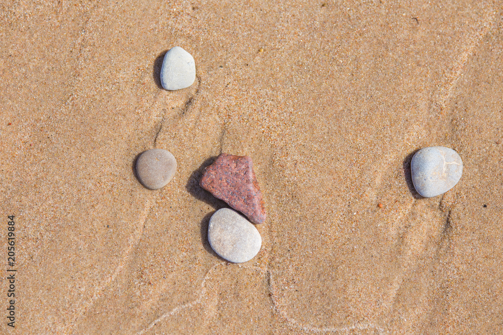 Beautiful smooth sea stones in the sands of the beach. Closeup photo of stone textures and shapes. Beautiful smooth sea stones in the sands of the beach. Closeup photo of stone textures and shapes.
