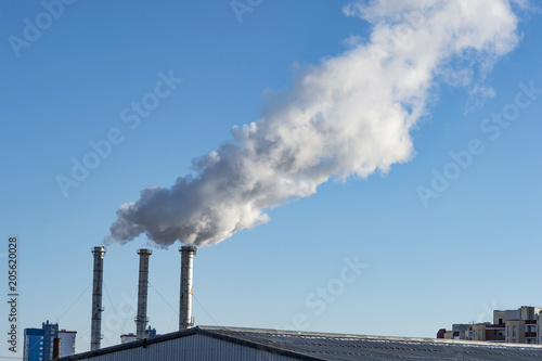 industrial smoke from chimney on blue sky.