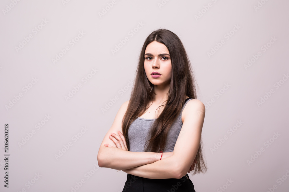 Confident serious woman with crossed hands on gray background. Confident serious woman with crossed hands on gray background.
