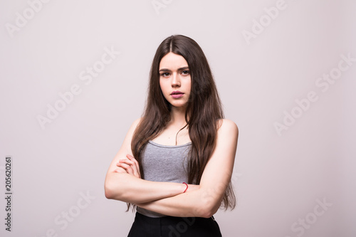 Portrait of beautiful business woman standing with hands folded and looking at camera over white background