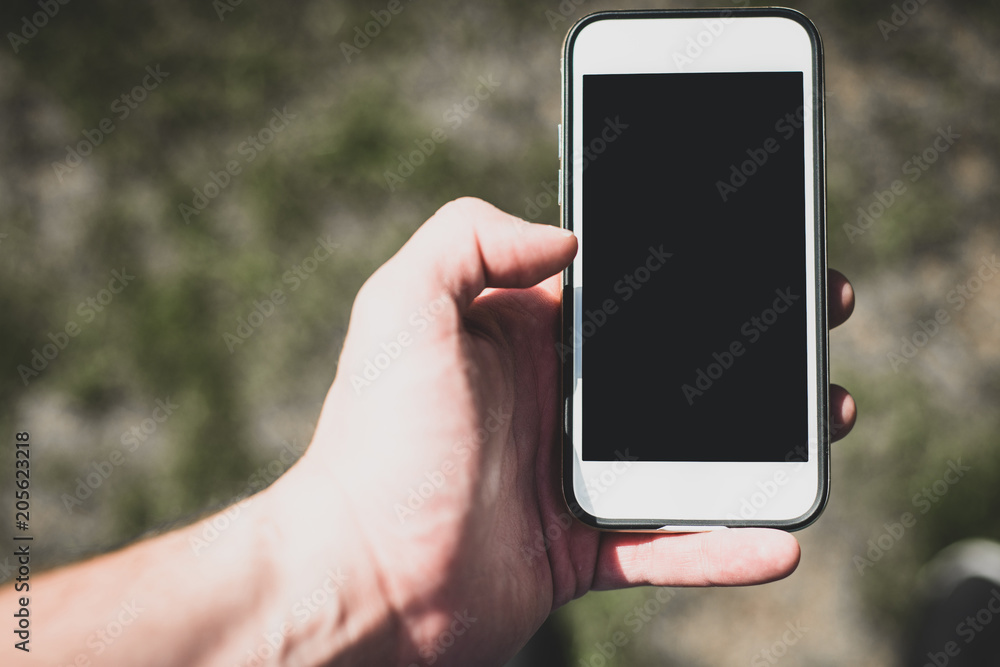 Telephone in hand. White phone with a blank display. Phone ready to be filled with content.