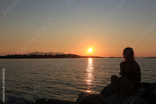 Girl in sunset in harbor in Northern Norway