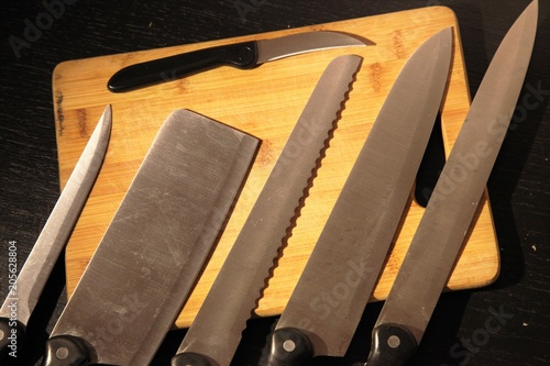 A set of professional kitchen knives on a black table..