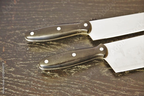 A set of professional kitchen knives on a black table..