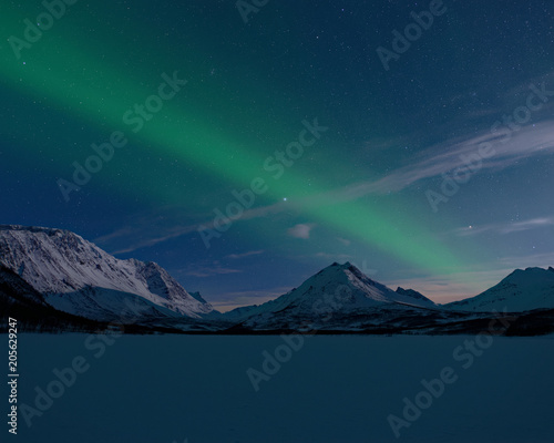 Sterne und Nordlicht über dem zugefrorenen Nakkevatnet (Tromsø, Norwegen)
