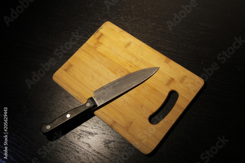 A set of professional kitchen knives on a black table..