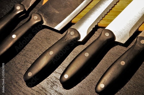 A set of professional kitchen knives on a black table..