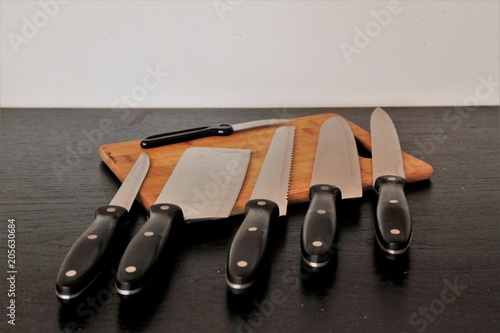 A set of professional kitchen knives on a black table..