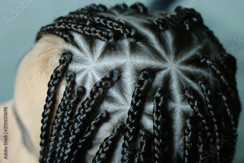 youth hairstyle in an African style, close-ups, a lot of thin plaits for a girl, a background for an inscription photo