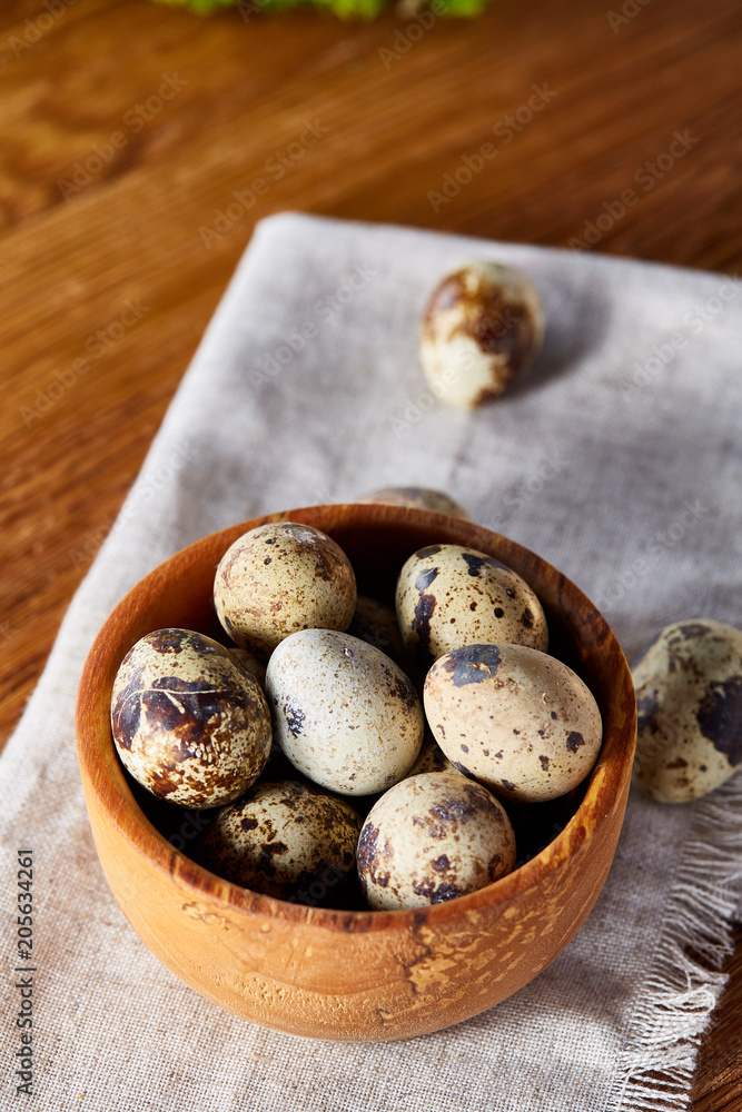 Bowl with eggs quail, eggs on a homespun napkin on wooden table, close-up, selective focus Bowl with eggs quail, eggs on a homespun napkin on wooden table, close-up, selective focus