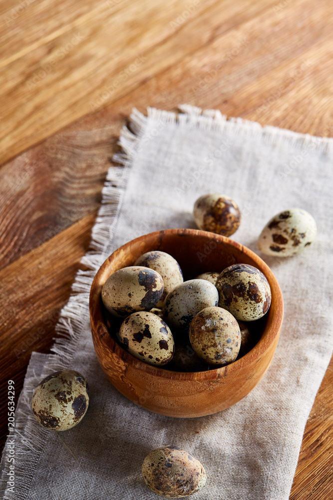 Bowl with eggs quail, eggs on a homespun napkin on wooden table, close-up, selective focus Bowl with eggs quail, eggs on a homespun napkin on wooden table, close-up, selective focus