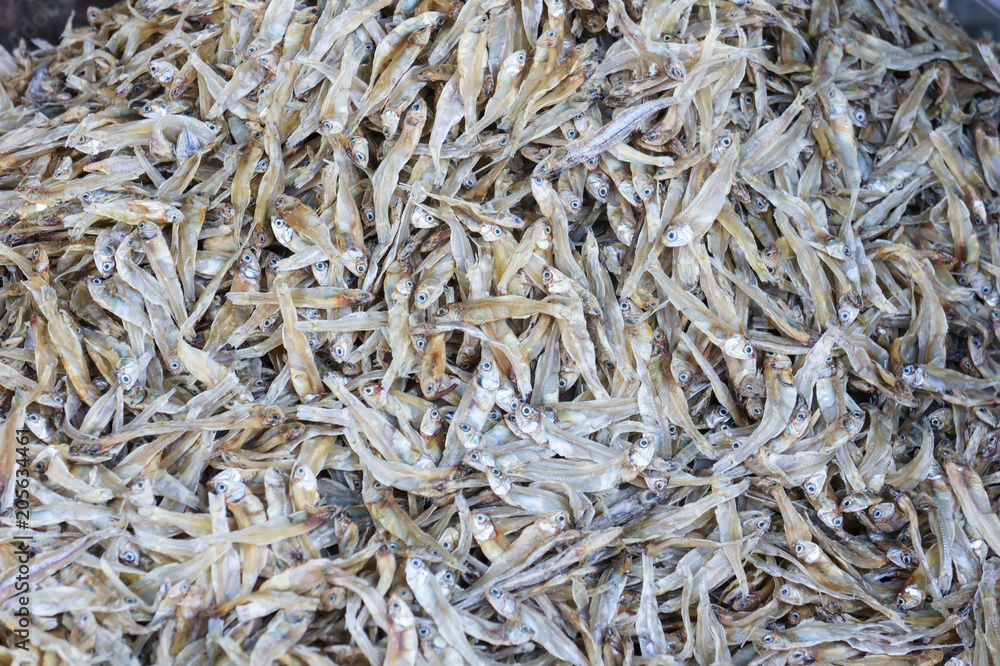 Stack of small dried fish from sea on fish market jetty. For seafood, food, kitchen, texture and background.