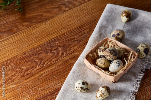 Quail eggs in the container over rustic wooden table, close-up, high angle view, selective focus.