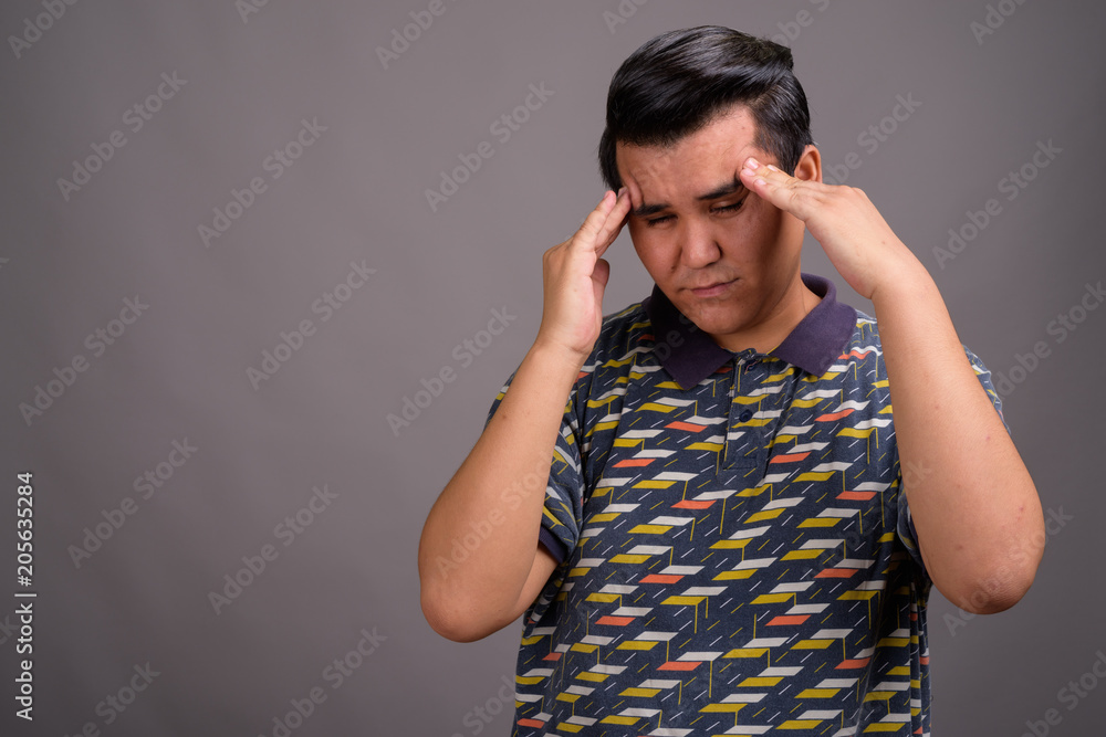 Young multi-ethnic man against gray background Young multi-ethnic man against gray background
