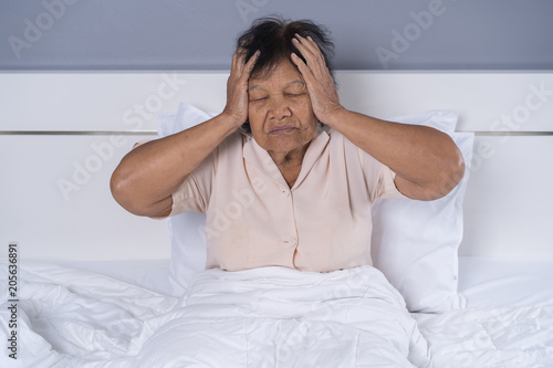 Senior woman got a headache on bed