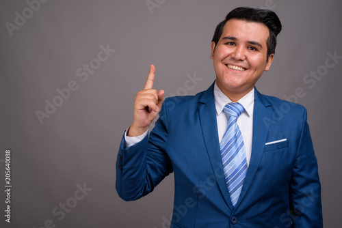 Young multi-ethnic businessman against gray background