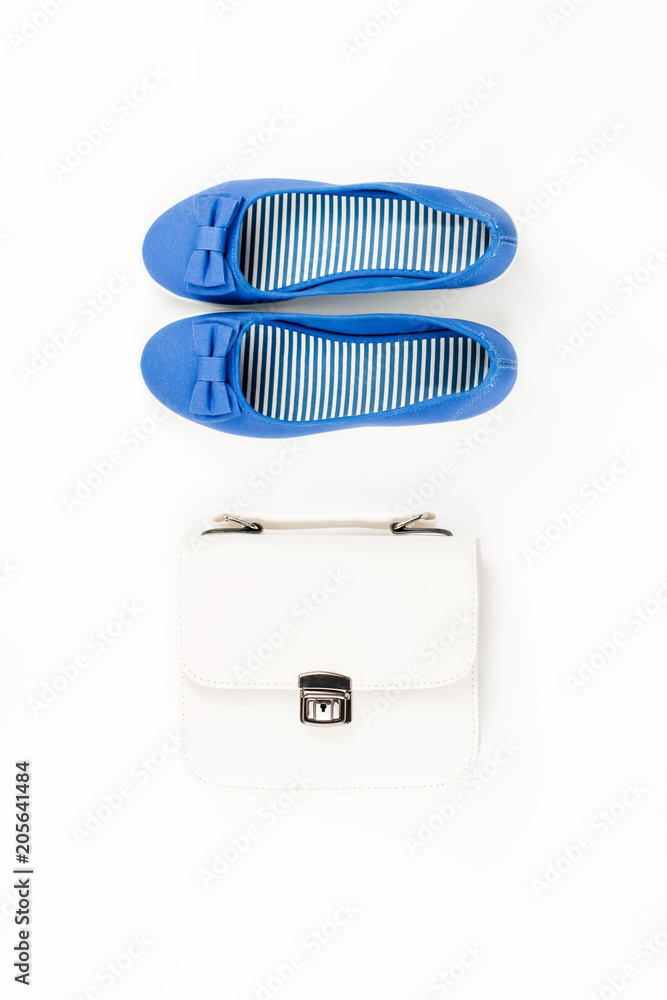 Female summer fashion accessories flat lay with blue flats and white purse Female summer fashion accessories flat lay with blue flats and white purse