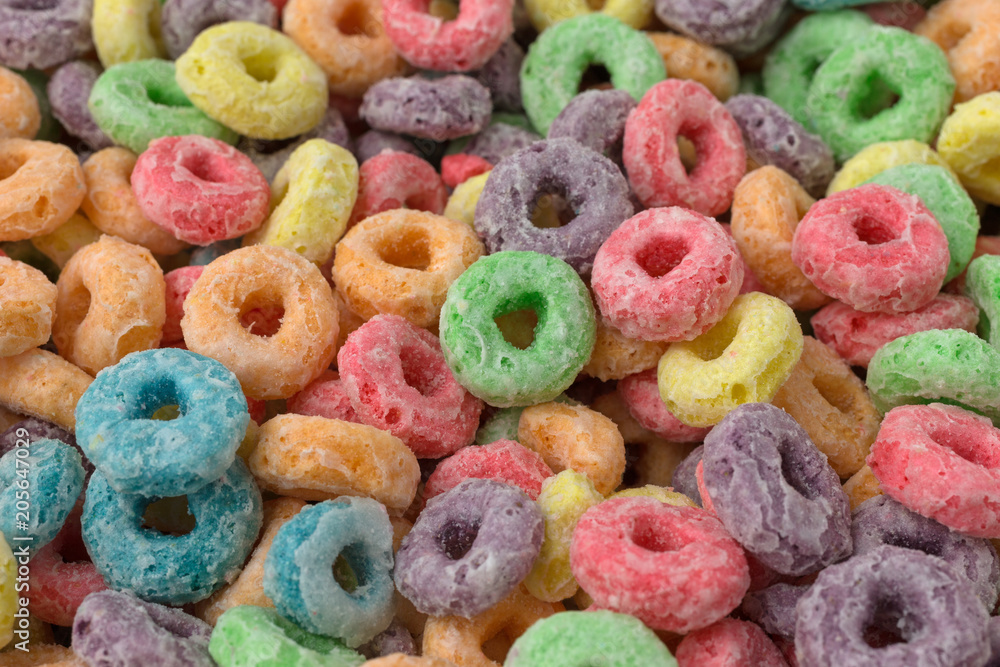 Very close view of dry sugar coated fruity flavored cereal.